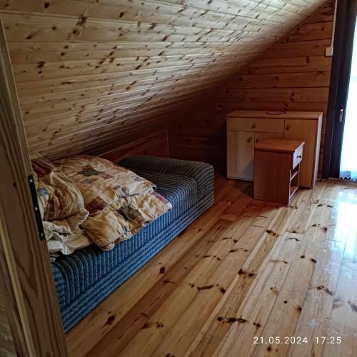 a bedroom with a bed and a wooden floor at Camping Bałtyk in Dźwirzyno