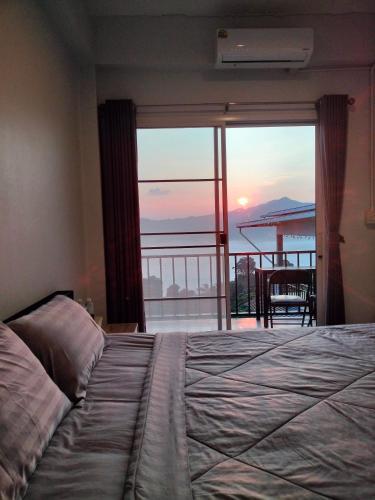 a bedroom with a bed and a view of a balcony at อามา ภูลังกา เฮาส์ in Ban Sakoen