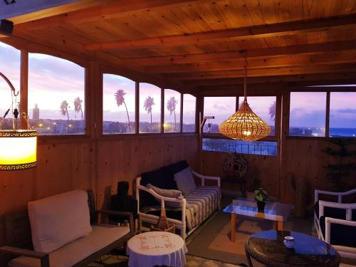a living room with a couch and a chandelier at Art riad au bord de la mer 1 in El Jadida