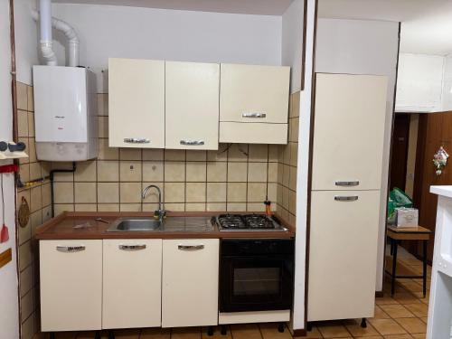 a kitchen with white cabinets and a sink and a stove at CASA MASSI in Caramanico Terme