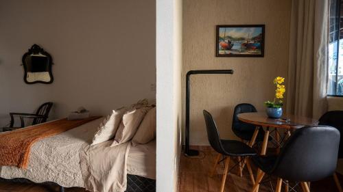 a bedroom with a bed and a table with chairs at Acesso à Praia Ar Condicionado Conforto Garantido! in Saquarema