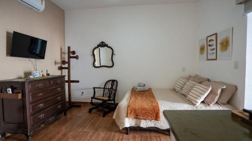 a bedroom with a bed and a dresser with a mirror at Acesso à Praia Ar Condicionado Conforto Garantido! in Saquarema