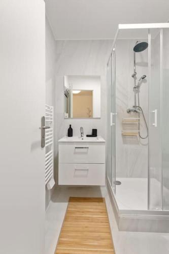une salle de bain blanche avec une douche et un lavabo dans l'établissement Studio cosy hyper-centre, à Bourg-en-Bresse