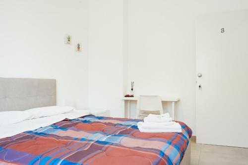a white room with a bed with a colorful blanket at CIVICO 15 BED BREAKFAST in Mercato San Severino