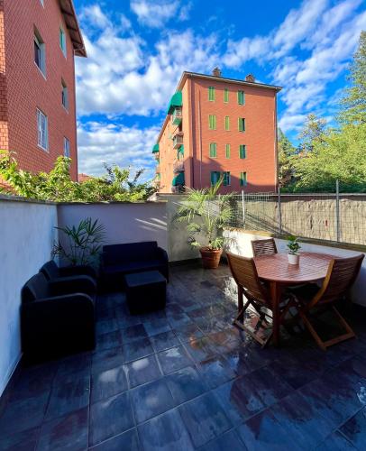 a patio with a table and chairs and a building at Home Cavour - Casalecchio - in Casalecchio di Reno