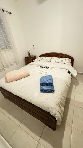 a bed with two blue towels on top of it at near the sea even 14 days won't feel enough in Bat Yam