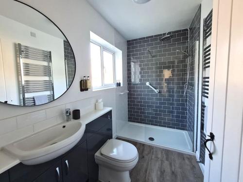 ein Badezimmer mit Waschbecken, Toilette und Spiegel in der Unterkunft 'Shakespeare Cottage' - Free Parking near Salisbury Railway Station & Walk to City in Salisbury