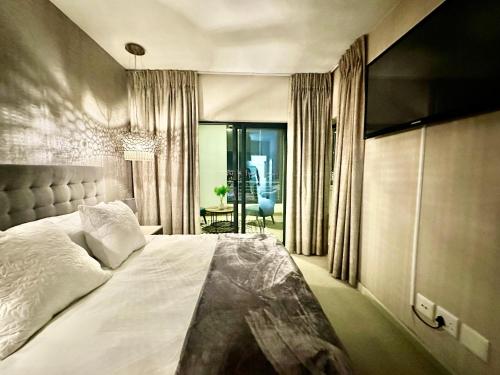 a bedroom with a large white bed and a table at Knightsbridge Luxury Escape in Cape Town