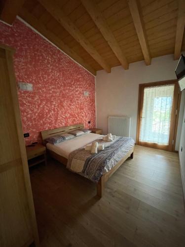 a bedroom with a bed and a red wall at Orobie Holiday Apartments in Albosaggia