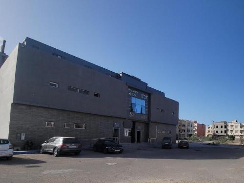 a large building with cars parked in a parking lot at Appartement Ghita Essaouira in Essaouira