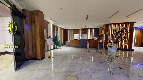 a lobby with a glass table in the middle of it at How inn Hotel in Al Madinah