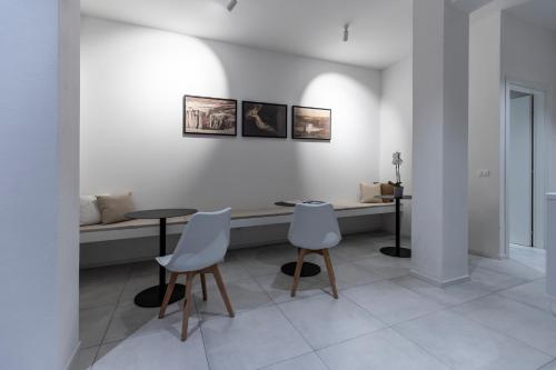 a white room with two tables and two chairs at Dantis Rooms in Ravenna