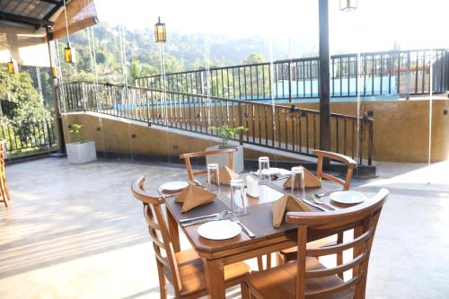 a table and chairs on a patio at Ceylon Ayu Resort Kandy in Kandy