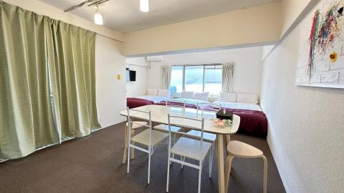 a room with a bed and a table and chairs at Nagai park side stay premium in Osaka