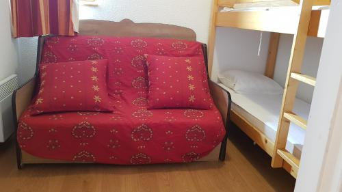 une chaise rouge dans un dortoir avec des lits superposés dans l'établissement Vos vacances à Saint François Longchamp, à Saint-François-Longchamp