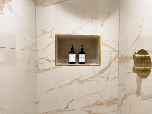 two bottles of wine on a shelf in a bathroom at Suite Ruby in Sélestat