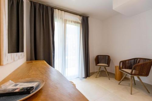 a room with a table and chairs and a large window at Blue Sea Suites in Afitos