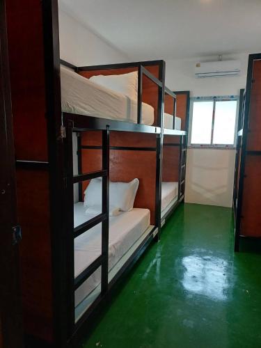 two bunk beds in a room with a green floor at Green Gen Hotel, Mueang Phuket in Phuket Town