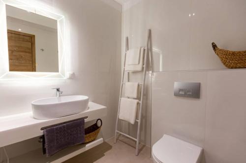 a white bathroom with a sink and a mirror at Blue Sea Suites in Afitos