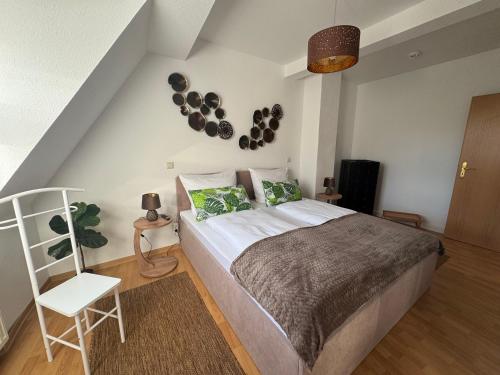 a bedroom with a large bed and a white chair at Naumburger Charme Traminer in Naumburg
