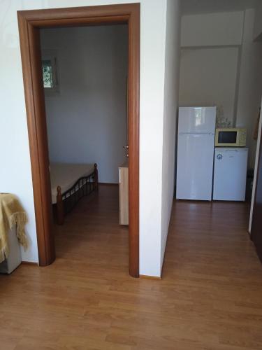 an open door to a room with a kitchen and a refrigerator at Apartment Michail 2 in Ayios Nikolaos Sithonia