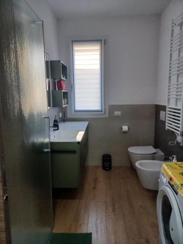 a bathroom with a sink and a toilet and a window at Donna di Coppe Apartment in Torre Boldone