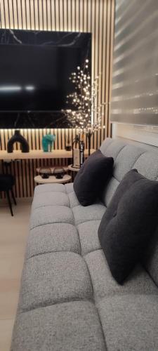 a couch with pillows in a living room with a television at Urban Nest Veria downtown in Veria