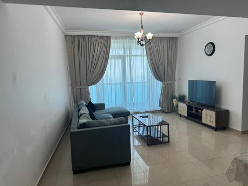ein Wohnzimmer mit Sofa und Fernseher in der Unterkunft Corniche Residence Tower in Ajman 
