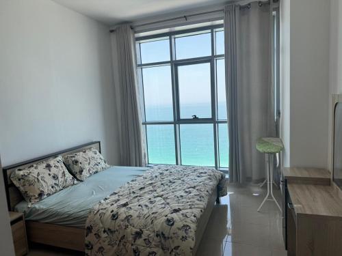 sypialnia z łóżkiem i dużym oknem w obiekcie Corniche Residence Tower w mieście Adżman