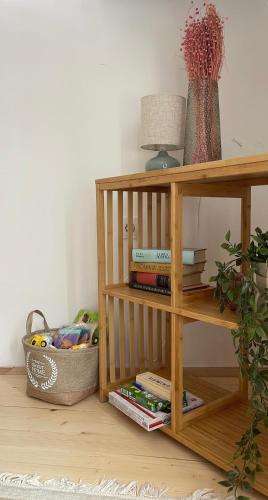 a wooden book shelf with books and a basket at House Ashik in Sarajevo