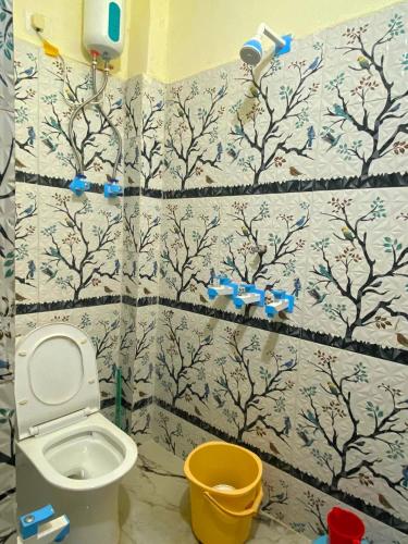 a bathroom with a toilet and a wall at BSSN Guest House in Gwalior