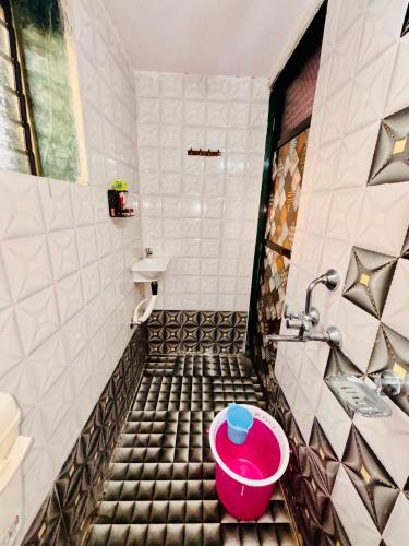 a bathroom with a pink bowl on the floor at Sai Ekvira Farms in Surai