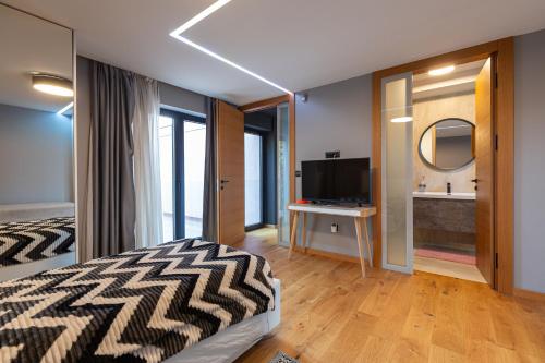 a bedroom with a bed and a television and a bathroom at Villa Bella in Sarajevo