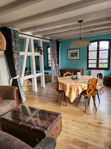 un salon avec une table, des chaises et un canapé dans l'établissement La Petite Alsacienne, à Strasbourg