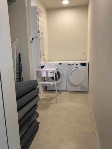 a laundry room with a washing machine and a washer at Beach House Terra in Zeebrugge