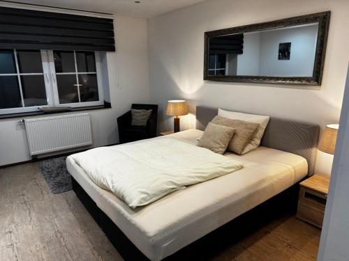 a bedroom with a large bed with a mirror on the wall at Hotel & Restaurant Brommler Mühle in Gangelt