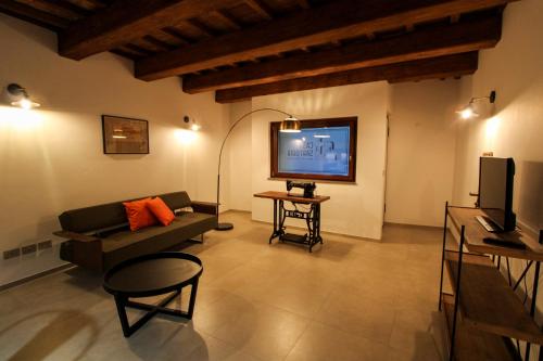 a living room with a couch and a flat screen tv at Casa Sartoria - Guest House in Pergola