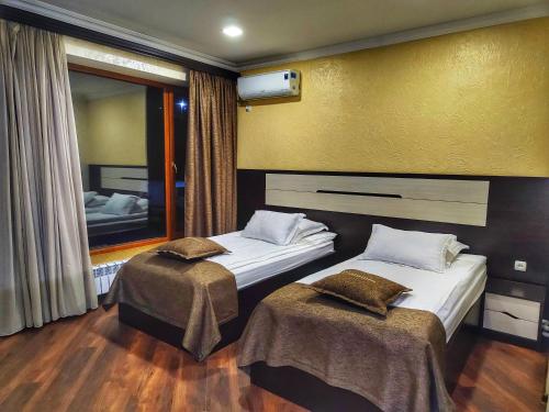 two beds in a hotel room with a mirror at Yerak hotel in Lalvar