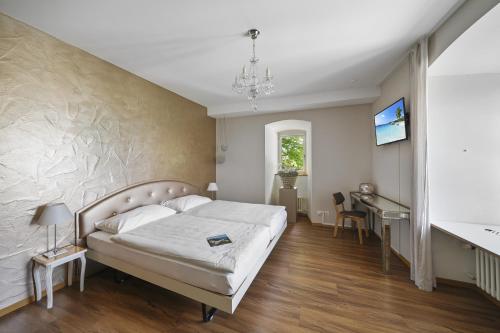 a bedroom with a bed and a desk at Schloss Wartensee in Rorschacherberg