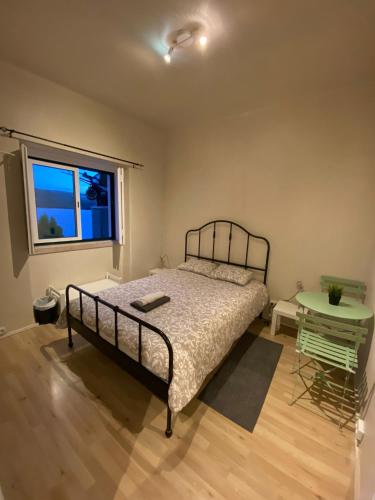 a bedroom with a bed and a table and a window at CHALLET AZENHAS in Bolembre de Baixo