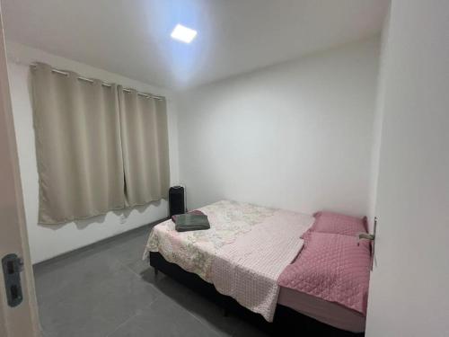 a bedroom with a bed with a pink blanket at Apartamento prox Outlet Campo Largo, BR e Hospitais, possui lava e seca in Campo Largo