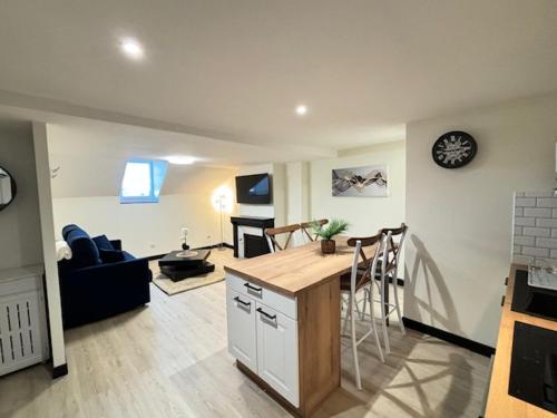 une cuisine et un salon avec une table et des chaises dans l'établissement Appartement 7 Climatisé havre de paix ,cosy au cœur de Limoges, à Limoges