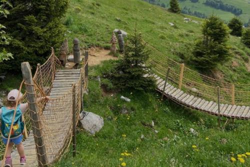a young girl is standing on a suspension bridge at Chalet Bergdoktor in Amden
