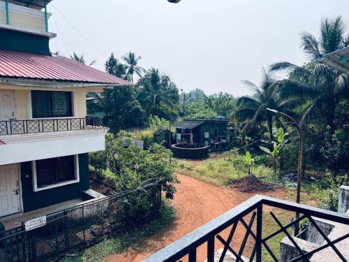 a balcony of a house with a dirt road at Susneh Homestay Reena Cottage in Srīvardhan
