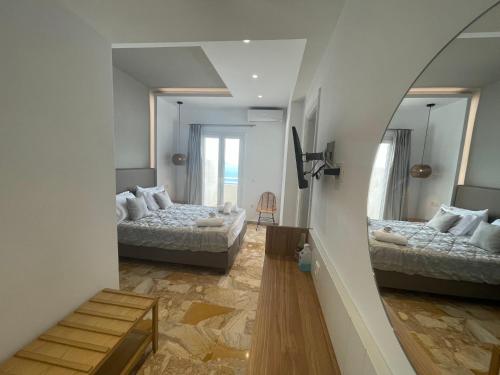 a room with two beds and a mirror at Kokkinos Villas in Akrotiri