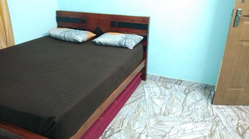 a bedroom with a bed with a wooden headboard at Aamis Home Stay in Vattavada
