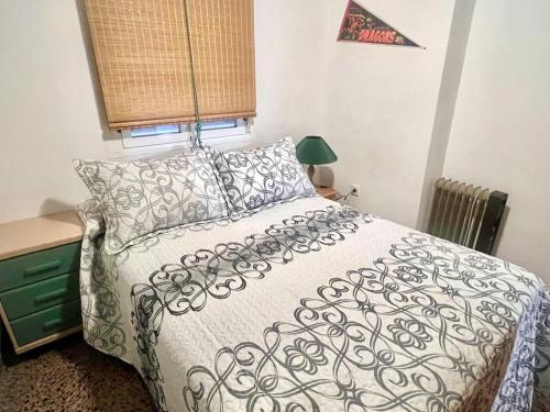 a bedroom with a bed with a black and white comforter at Apartamento Bonalba, Golf, Playas y Piscinas in Mutxamel