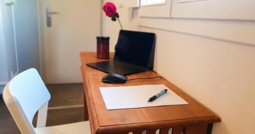 - un bureau avec un ordinateur portable et un stylo sur papier dans l'établissement Le nid des Teinturiers - rooftop view - AC, à Avignon