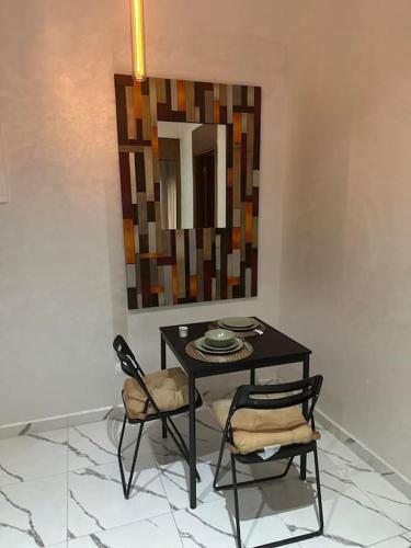a dining room table with two chairs and a mirror at Magnificent Cozy New Luxury Condo in Prime Casablanca Location in Les Camps