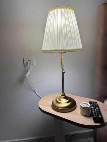 a lamp sitting on a table with a remote control at Magnificent Cozy New Luxury Condo in Prime Casablanca Location in Les Camps